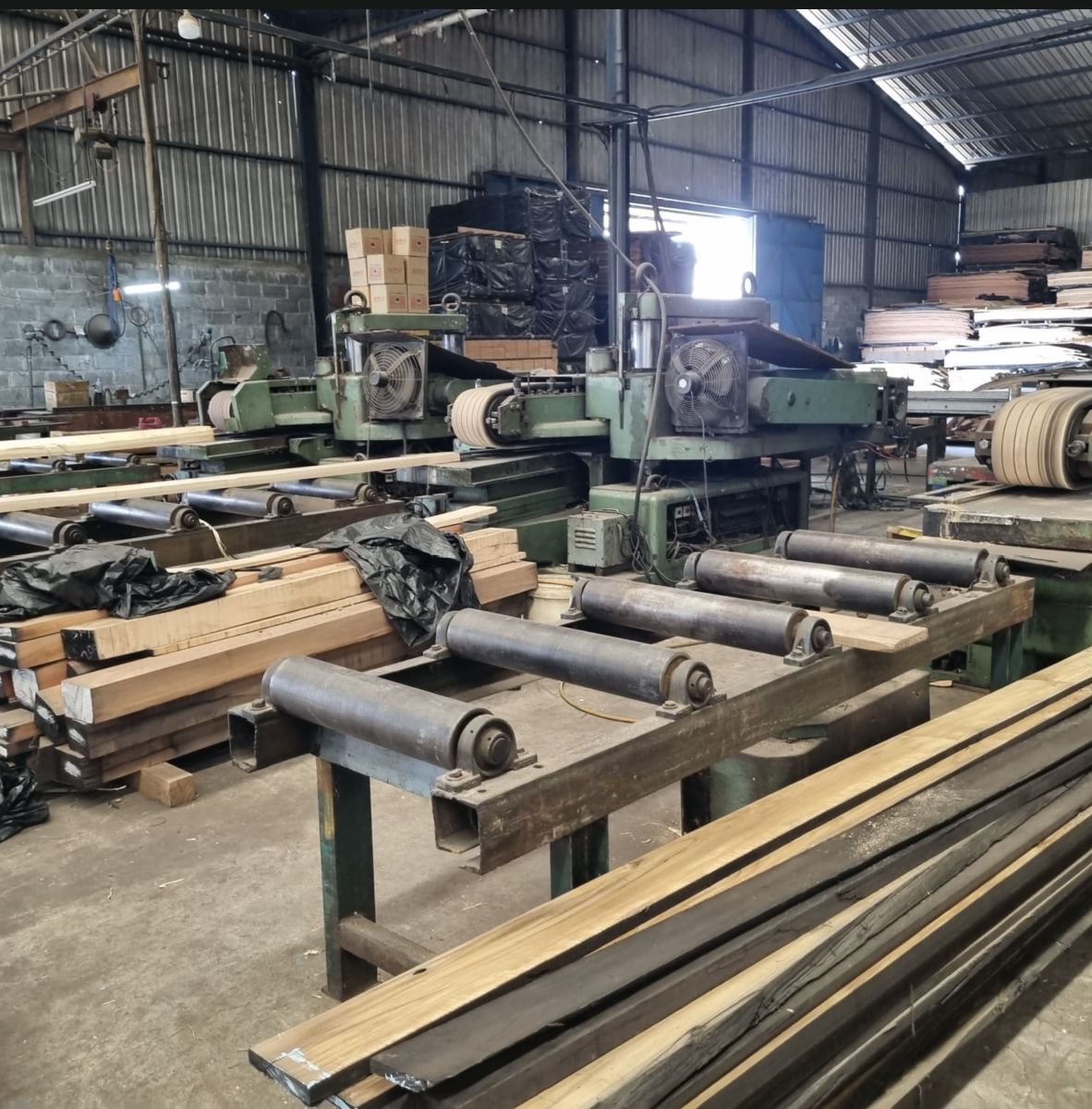 Sawmill line with roller conveyors and cut timber